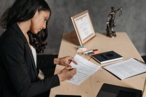 A lawyer or businesswoman reviews paperwork in an office setting.